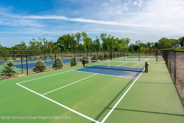 view of tennis court with community basketball court and fence