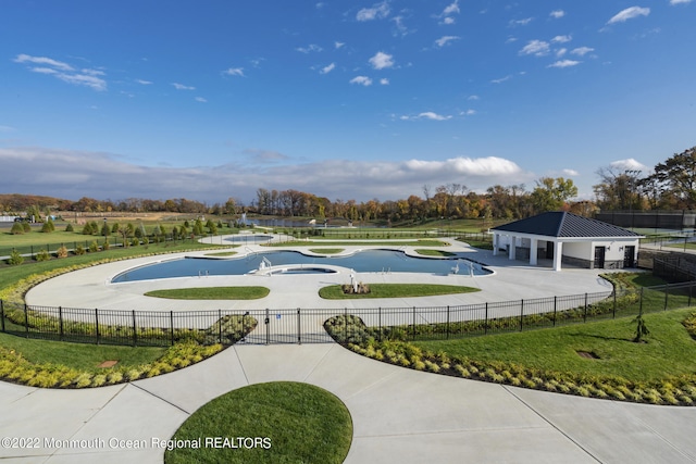 view of community featuring curved driveway and fence