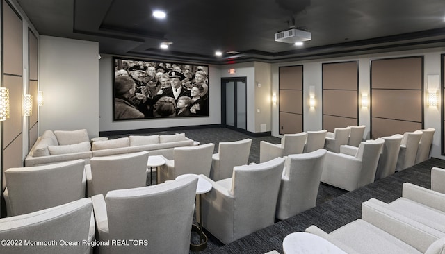 cinema with a tray ceiling and carpet
