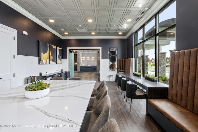 interior space featuring ornamental molding, an ornate ceiling, recessed lighting, and wood finished floors