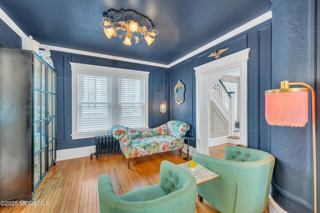 sitting room featuring stairs, wood-type flooring, and baseboards