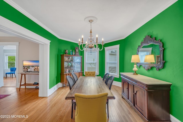 dining room with a chandelier, baseboards, light wood-style floors, and crown molding