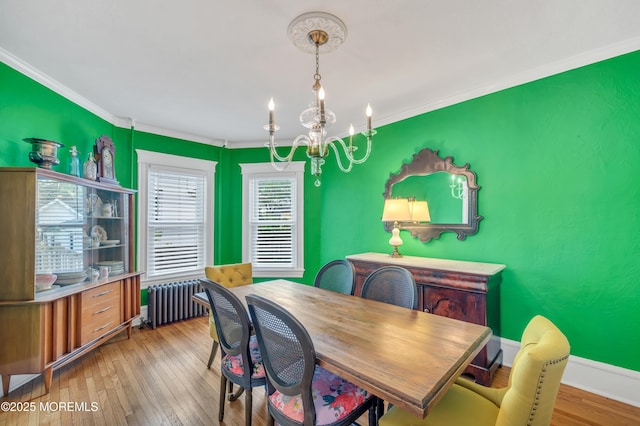 dining room featuring radiator heating unit, a chandelier, ornamental molding, and hardwood / wood-style floors
