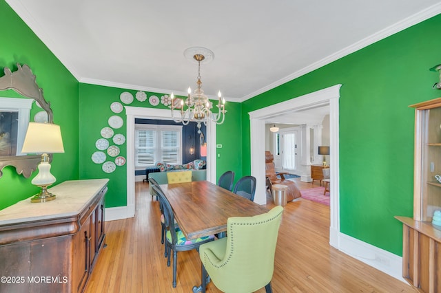 dining area featuring a chandelier, ornamental molding, light wood-style flooring, and baseboards