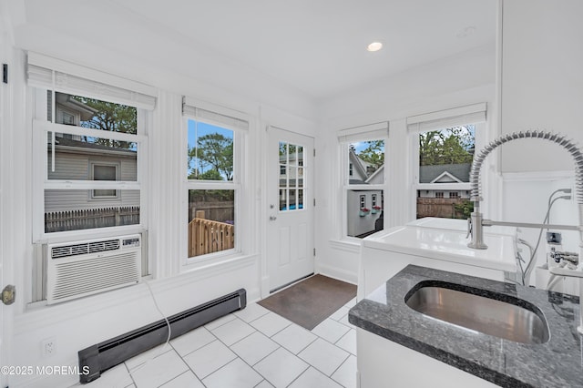 kitchen featuring a baseboard heating unit, tile patterned flooring, dark stone counters, a sink, and recessed lighting