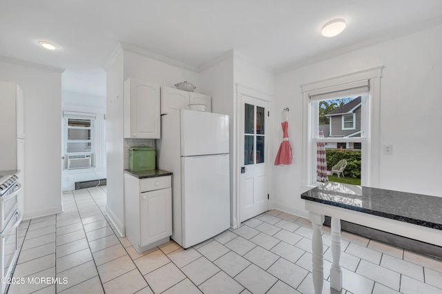 kitchen featuring freestanding refrigerator, white cabinets, light tile patterned floors, cooling unit, and dark stone counters