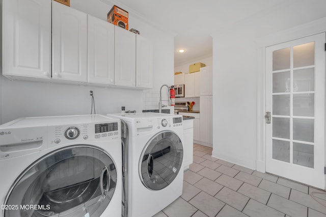 laundry room with separate washer and dryer, cabinet space, and recessed lighting