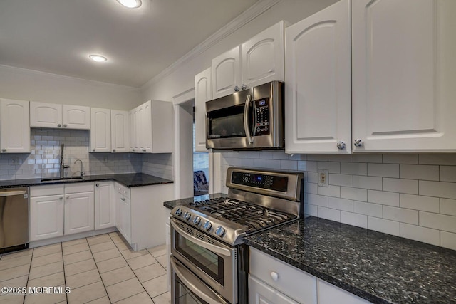 kitchen with appliances with stainless steel finishes, a sink, crown molding, white cabinetry, and backsplash