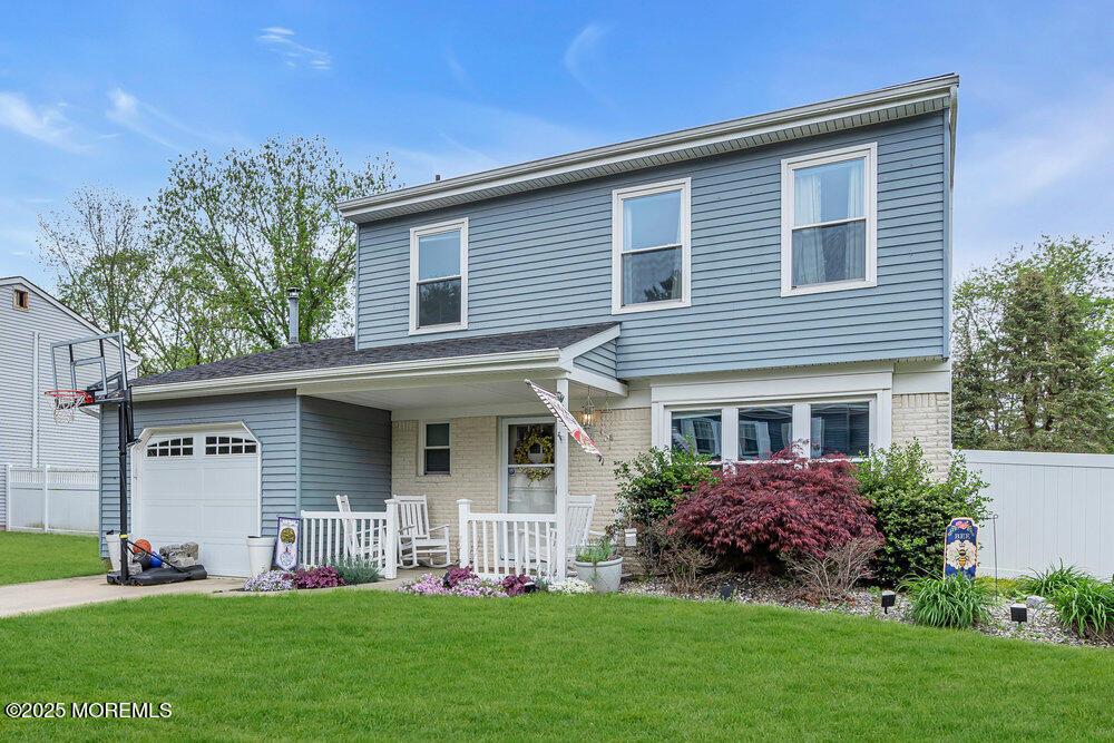 4 Dantley Dr, Howell, NJ 07731 - traditional-style house with covered porch, an attached garage, and brick siding