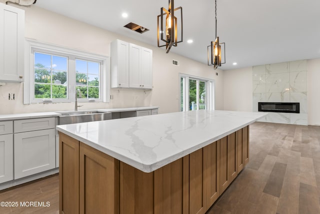 38 Louise Dr, East Brunswick, NJ 08816 - kitchen featuring a sink, wood finished floors, a center island, light stone countertops, and recessed lighting