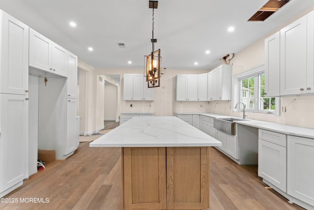 38 Louise Dr, East Brunswick, NJ 08816 - kitchen featuring a sink, recessed lighting, light wood-type flooring, light stone countertops, and a kitchen island