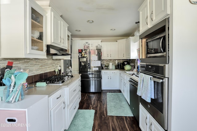 kitchen with appliances with stainless steel finishes, under cabinet range hood, white cabinetry, light countertops, and recessed lighting