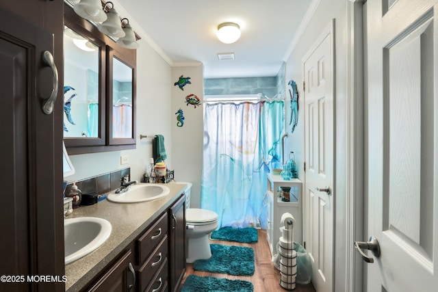 full bathroom with a shower with curtain, ornamental molding, wood finished floors, double vanity, and toilet