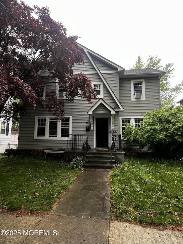 view of front facade with cooling unit and a front lawn