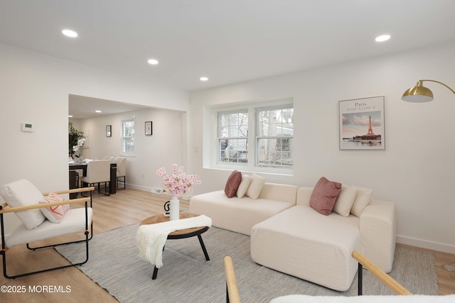 living area with light wood-style flooring, baseboards, and recessed lighting