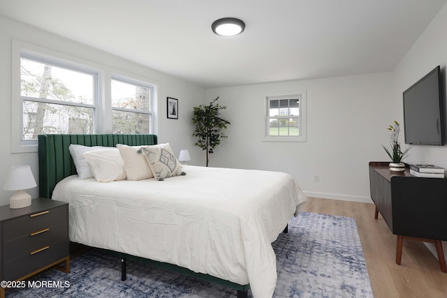 bedroom with light wood-style floors and baseboards