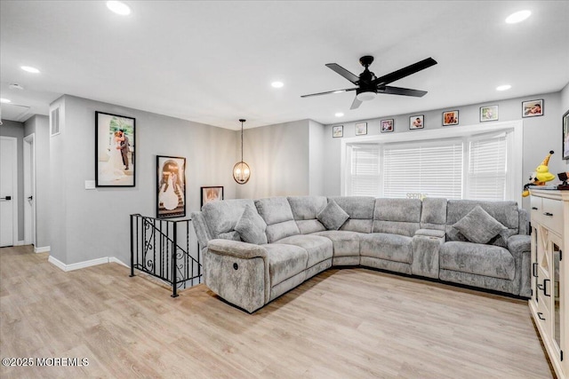 living area with recessed lighting, ceiling fan with notable chandelier, baseboards, and light wood-style floors
