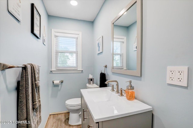 bathroom with vanity, toilet, plenty of natural light, and wood finished floors