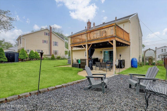 rear view of house with a storage shed, a patio, a deck, fence, and a yard
