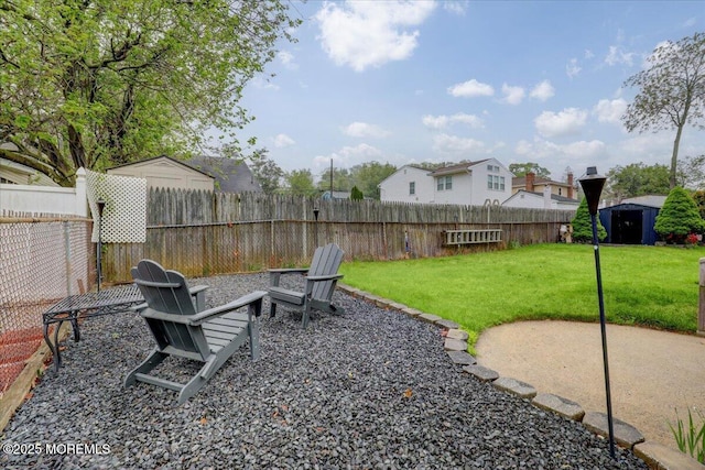 view of yard featuring a fire pit, a patio area, and fence