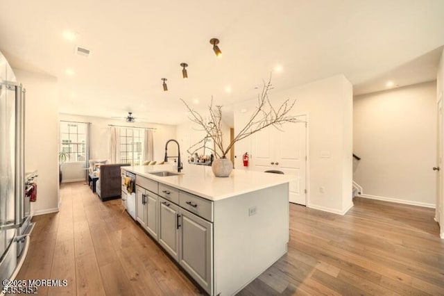 2206 Evans Ln, Middletown, NJ 07748 - kitchen featuring light wood finished floors, a sink, open floor plan, a kitchen island with sink, and gray cabinets