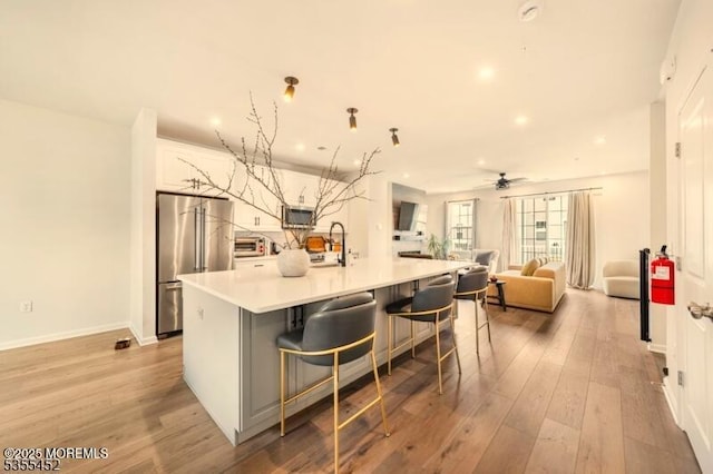 2206 Evans Ln, Middletown, NJ 07748 - kitchen featuring a sink, a spacious island, light wood-style flooring, a ceiling fan, and appliances with stainless steel finishes