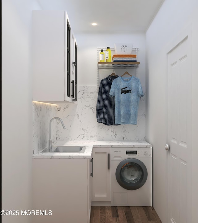 clothes washing area with a sink, washer / clothes dryer, dark wood-style flooring, and cabinet space