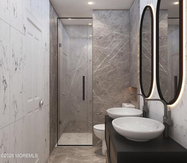 full bath featuring double vanity, toilet, a marble finish shower, tile walls, and marble finish floor