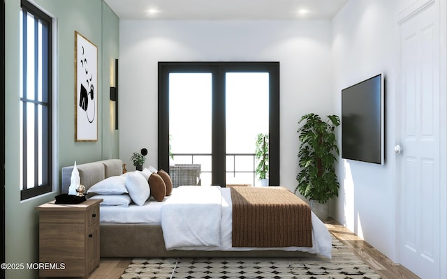 bedroom with light wood finished floors and multiple windows
