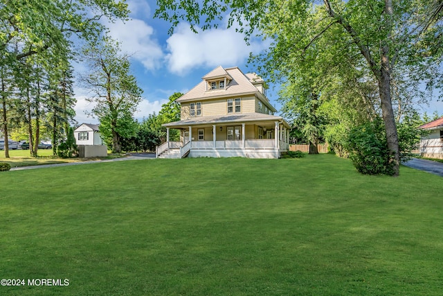 view of front facade featuring covered porch, a chimney, and a front yard