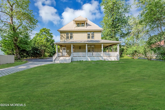 view of front of house featuring a front yard, aphalt driveway, and covered porch
