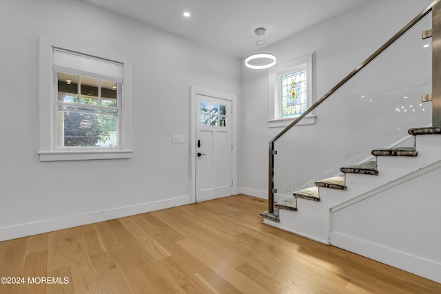 foyer entrance with stairs, baseboards, recessed lighting, and light wood-style floors