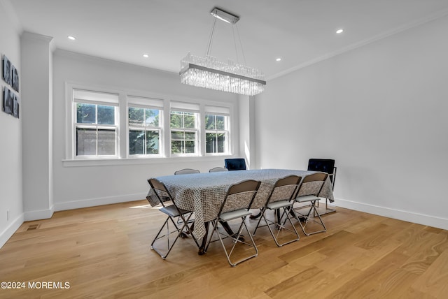 dining space with baseboards, light wood-style floors, a chandelier, and crown molding