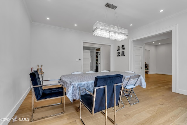 dining room featuring crown molding, baseboards, a chandelier, and light wood-style floors