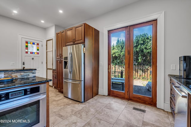 kitchen featuring recessed lighting, appliances with stainless steel finishes, visible vents, and dark stone countertops