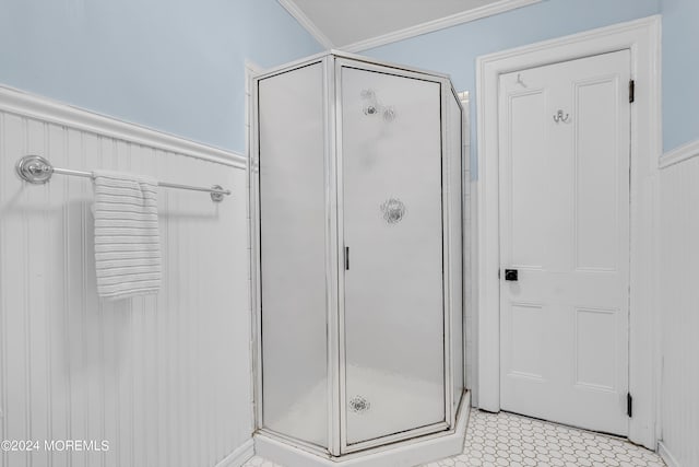 bathroom with ornamental molding and a shower stall