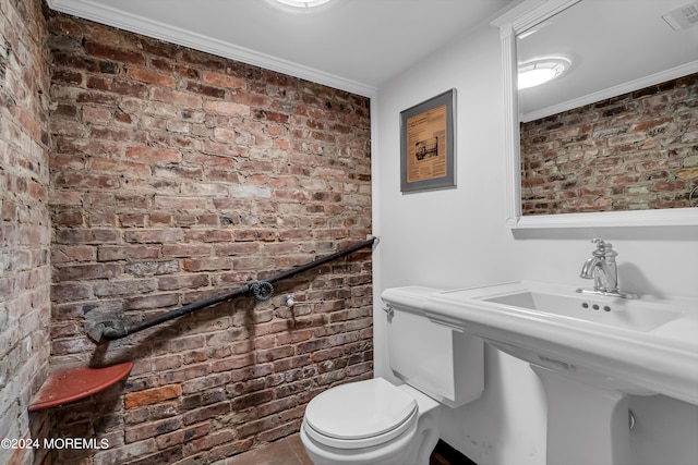 bathroom with toilet, crown molding, brick wall, and visible vents