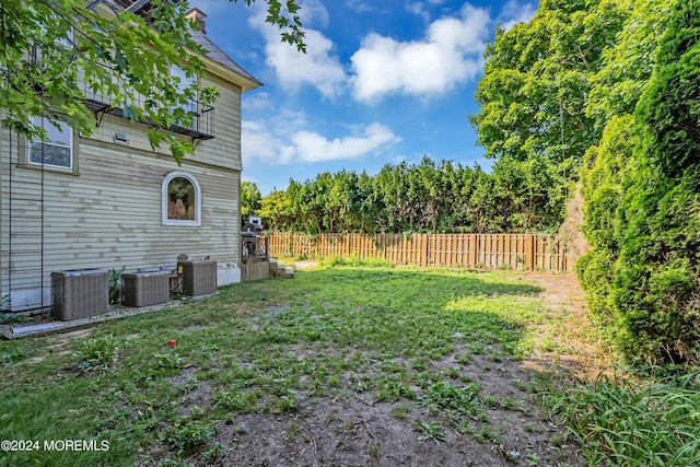 view of yard featuring central air condition unit and fence
