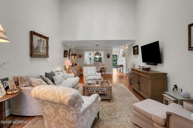 living room featuring a high ceiling, wood finished floors, and baseboards
