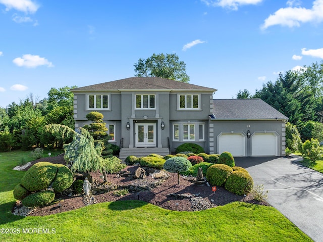 19 Dartmoor Dr, Manalapan, NJ 07726 - view of front of house with french doors, an attached garage, stucco siding, driveway, and a front lawn