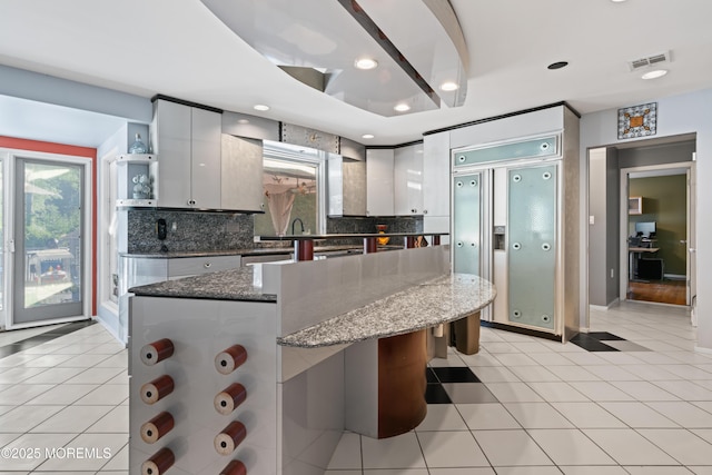19 Dartmoor Dr, Manalapan, NJ 07726 - kitchen with open shelves, decorative backsplash, a center island, light tile patterned floors, and recessed lighting