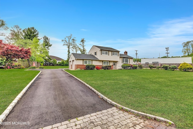 split level home with brick siding, driveway, and a chimney
