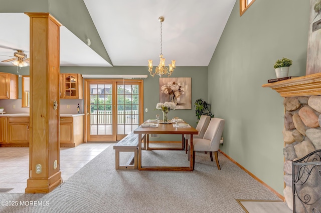 dining room with a chandelier, light tile patterned flooring, a ceiling fan, light colored carpet, and high vaulted ceiling