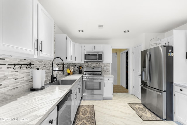 1 Skylark Dr, Jackson, NJ 08527 - kitchen featuring appliances with stainless steel finishes, decorative backsplash, white cabinetry, and light marble finish floors