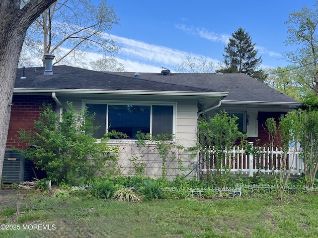 view of front of property with roof with shingles and central AC unit