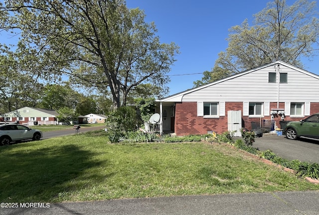 view of side of home featuring brick siding and a lawn