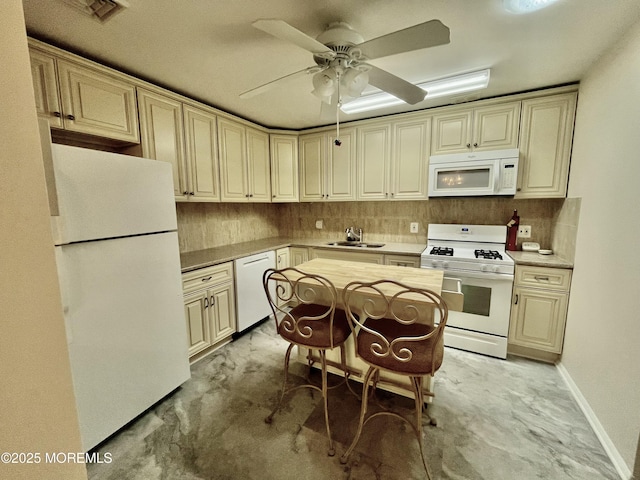 kitchen featuring white appliances, a sink, cream cabinetry, backsplash, and a ceiling fan