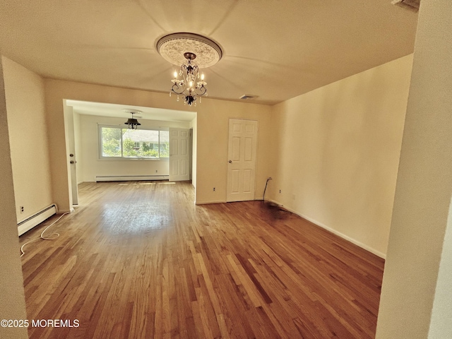 unfurnished dining area with a baseboard radiator, baseboard heating, wood finished floors, a chandelier, and baseboards