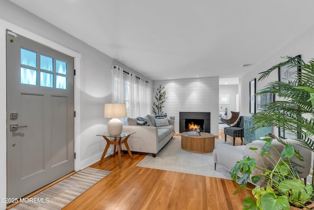 living area with light wood finished floors, baseboards, a fireplace, and recessed lighting