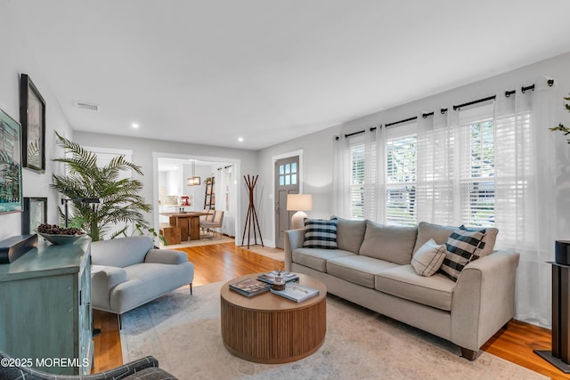 living area with light wood finished floors and recessed lighting
